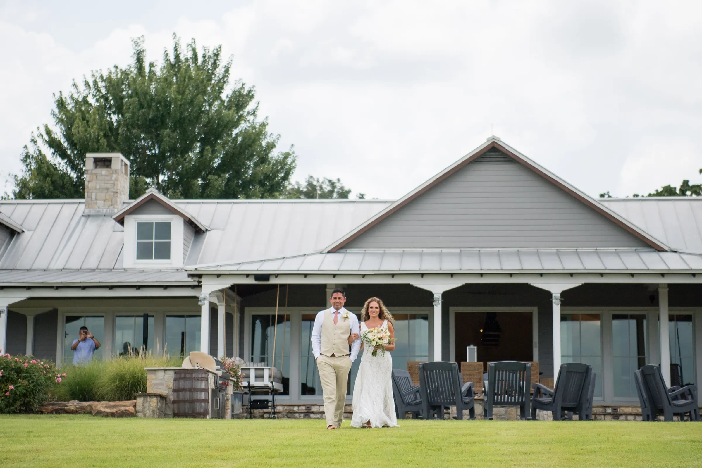 A bride and groom on the lawn in front of the main lodge at Pine Cone Ranch