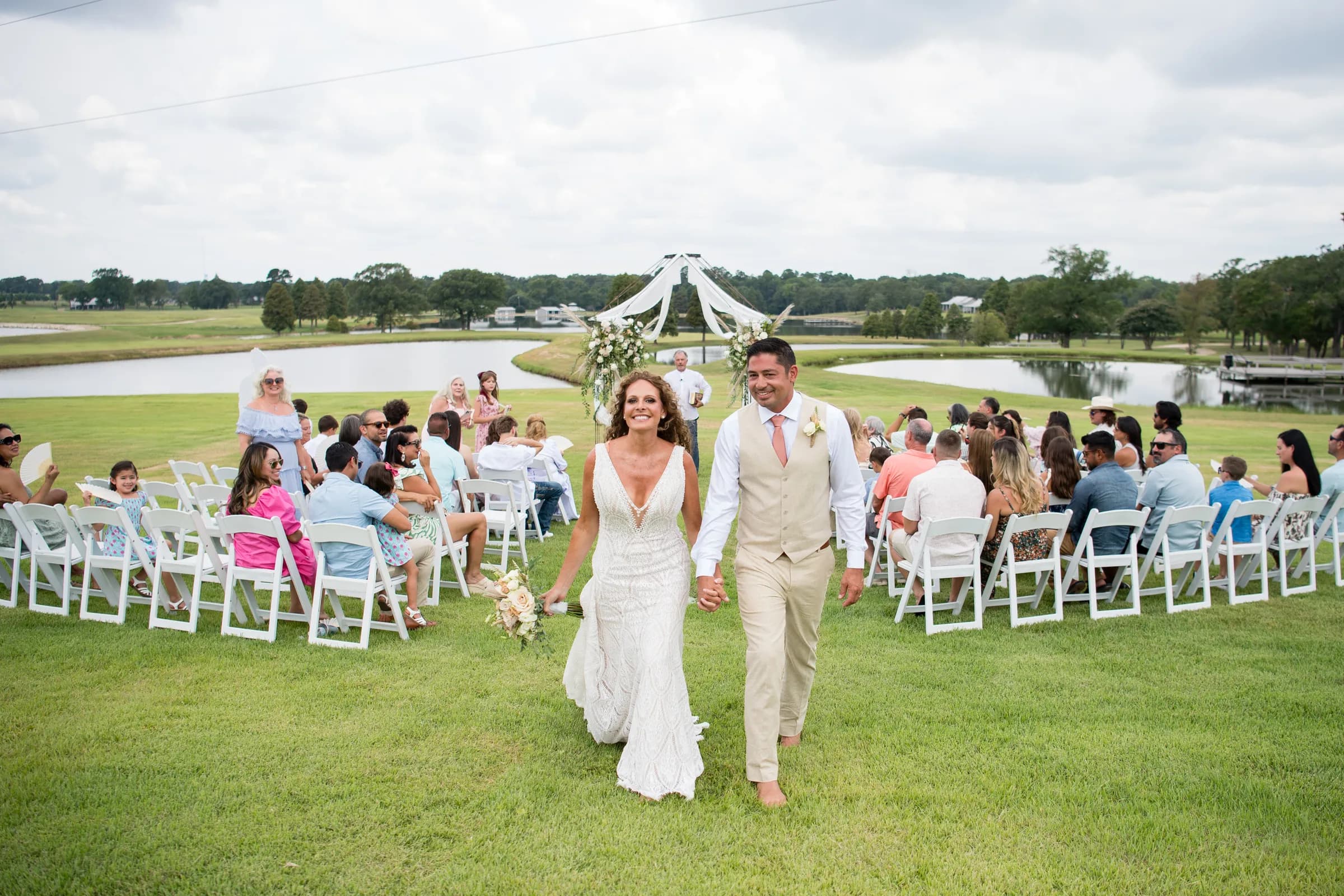 Newlyweds walking back up the aisle past their guests